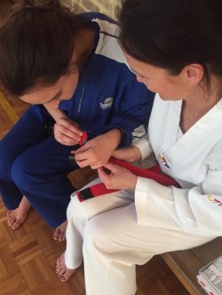 Head Instructor Miss Ajana Plunkett Striper Up Melanie Buhlman after passing her grading - www.tkdcentral.com